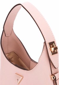Borsa a mano rosa chiaro con un esterno texture, logo triangolo dorato e una tracolla marrone. Presenta un interno spazioso con una fodera liscia.