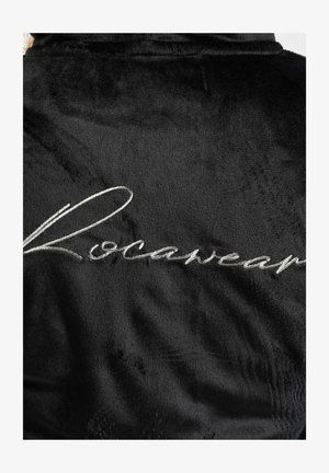Sort plydsrobe med en glat tekstur og sølvbroderet "Rocawear" logo på ryggen. Simpelt design med en blød finish.