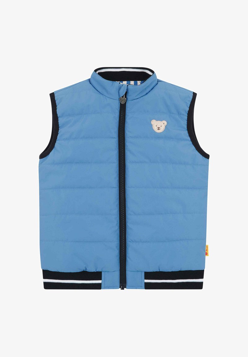 Niebieska kamizelka bez rękawów z pikowaniem, z suwakiem z przodu, czarnym wykończeniem na otworach na ramiona i na dole oraz małą beżową naszywką z misiem na piersi.