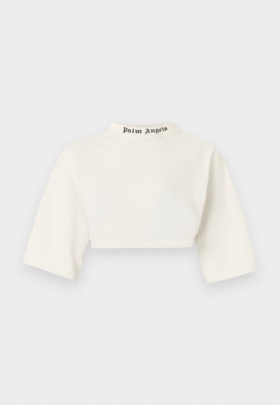 Λευκό κοντό τοπ με φαρδιά μανίκια τριών τετάρτων και ψηλό γιακά με το κείμενο «Palm Angels» σε μαύρη γοτθική γραμματοσειρά.
