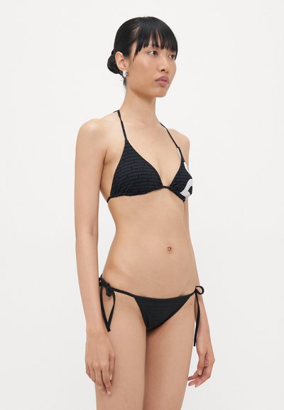 Black bikini features a textured triangle top with a printed design, adjustable ties on the sides, and a matching low-rise bottom.