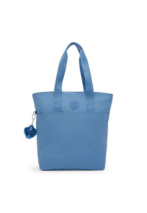Bolsa tote azul con dos asas para el hombro, bolsillo delantero, logo circular y pequeño llavero de gorila azul enganchado en el lateral.