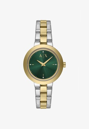 Kuld- ja hõbetooniga kell, millel on ümmargune roheline kellane, kullatud käte, tundemärkide ja kristalli aktsendiga. Metalllingi disain.