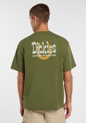 Camiseta de manga corta color verde oliva con un logo "Dickies Genuine Workwear" en blanco y amarillo en la espalda. Confeccionada con tela de algodón texturizada.