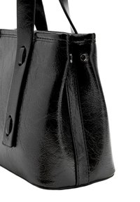 Czarna torebka ze sztucznej skóry o konstrukcyjnym kształcie, z gładką fakturą, płaskimi paskami oraz zatrzaskiem po boku.