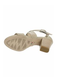 Sandal con tacco alto beige con più fasce trasversali, fibbia regolabile e suola in gomma texturizzata con un motivo sottile.
