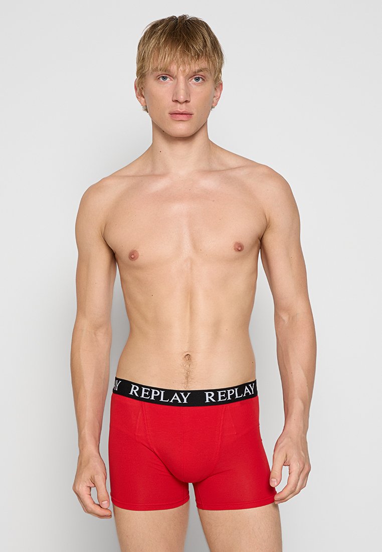 Rote Baumwoll-Boxershorts mit einem schwarzen elastischen Bund, auf dem "REPLAY" in weißer Schrift steht. Glatte Textur, enganliegendes Design und Oberschenkel-lange Passform.
