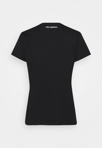 Camiseta negra de manga corta con forma ajustada. La parte trasera cuenta con un texto de logo en blanco en el cuello. Tejido suave con un diseño minimalista.