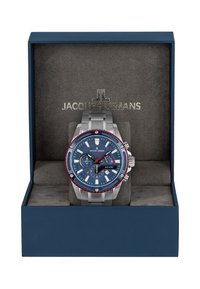 Sudraba nerūsējošā tērauda pulkstenis ar zilu ciparnīcu, sarkanu rāmi un hronogrāfa funkcijām. Pasniegts tumši zila krāsā kastē ar mīkstu pelēku iekštelpu.