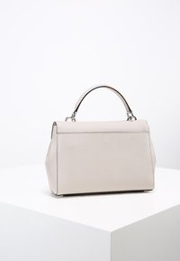 Strukturalna torebka z miękkiego, jasnoszarego materiału, z krótkim uchwytem i minimalnymi okuciami. Teksturowana powierzchnia z subtelnymi detalami ściegów.