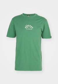 Camiseta de algodón verde con mangas cortas, cuello redondo y un logo bordado blanco en el frontal. Diseño simple sin patrones visibles.