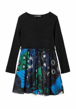 Haut noir à manches longues côtelé avec une taille froncée. Jupe fluide ornée de motifs floraux vibrants bleus, verts et noirs.