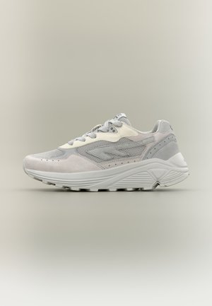 Hellgrauer und weißer Sneaker mit Mesh- und Wildlederpaneelen, gepolsterter Sohle und Schnürdesign, seitlich auf einem neutralen Hintergrund gezeigt.