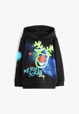 Sweat à capuche noir avec visage de renne vert néon, nez rouge, éclaboussures de peinture en spray bleue et rouge, et texte "Joyeux Noël" à l'avant.