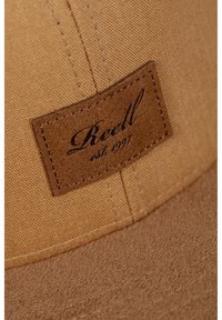 Brown cap with a textured, fabric upper and a soft, felted brim. Features a rectangular leather patch with "Reell est. 1997" embossed.