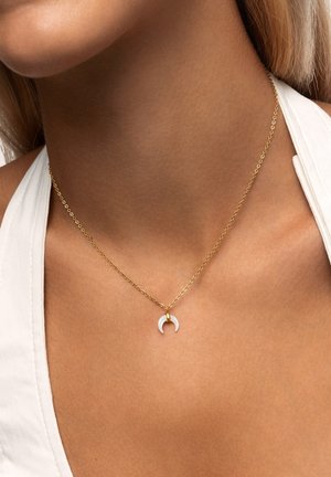 Guldhalsband med en liten vit halvmånependel, med en slät yta och minimalistisk design.