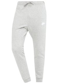 Ljusgrå Nike-joggingbyxor med elastisk midja, dragsko, avslutade anklar och vitt Nike-logotyp på övre vänstra låret.