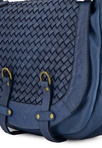 Vævet navy lædertaske med en glat nederste sektion, bronze hardware detaljer og spænder. Tekstureret overflade detaljer tydelige.