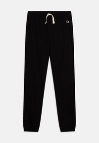 Pantaloni della tuta neri realizzati in tessuto morbido, con una vita elastica con cordino e polsini elastici alla caviglia. Dettaglio del logo sui fianchi.