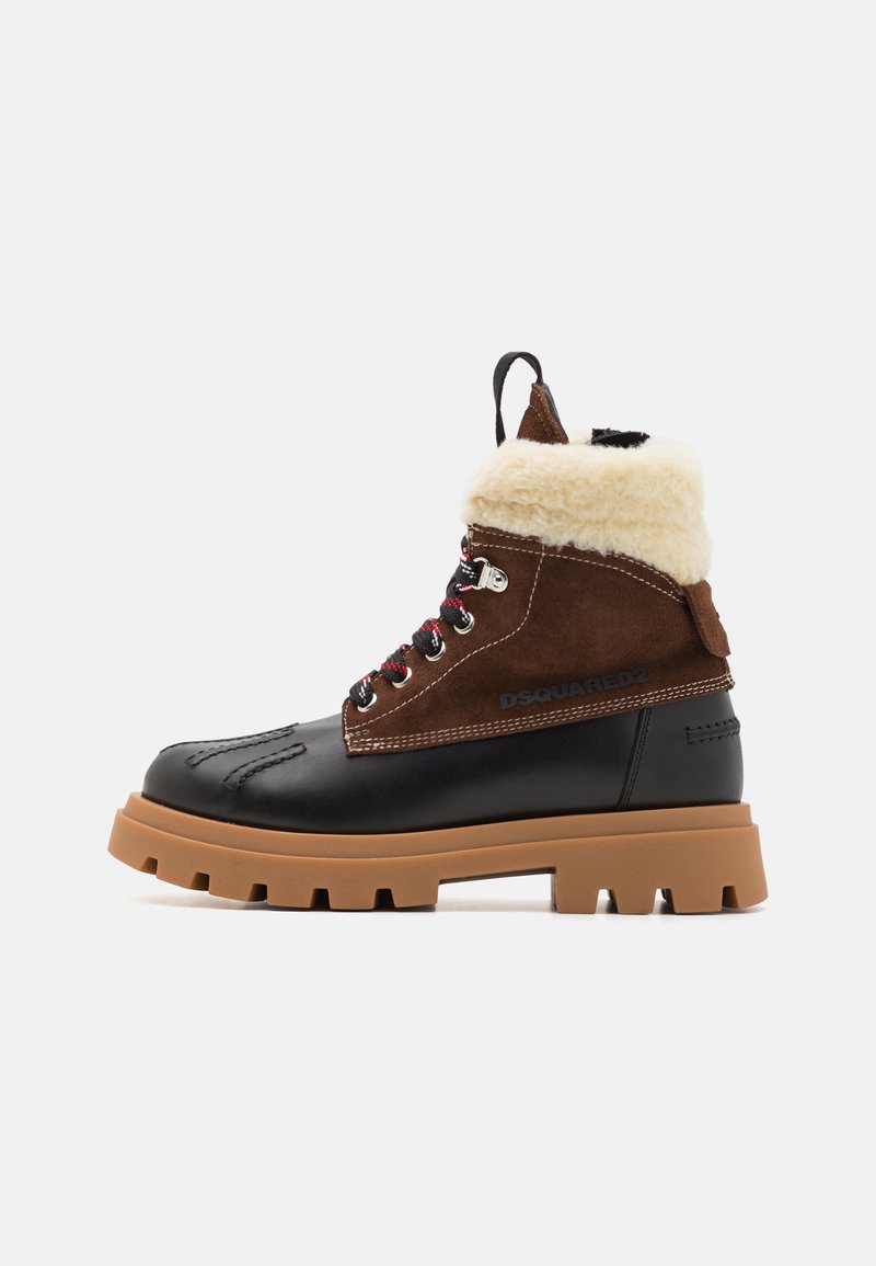 Brūni zamšveida un melni ādas potīšu zābaki ar krēmkrāsas pūkainu apkārtni, sarkaniem un melniem šņorēm, kā arī biezu brūnu gumijas zoli.