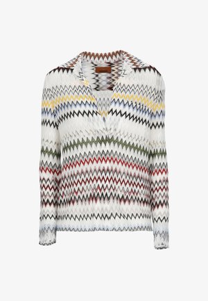 Blusa blanca de manga larga con patrones en zigzag multicolores en amarillo, azul, verde, rojo y negro, con escote en V y cuello.