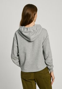 Grå hettegenser med avslappet passform, som har snor i hetta, ribbestrikkede mansjetter og et mykt, teksturert stoff.