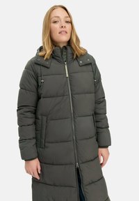 Lang, mørkegrå pufferjakke med hætte, der har horisontale quiltede sektioner, sidelommer, frontlynlås og justerbare snore.