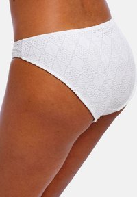 Bas de bikini blancs avec un motif géométrique texturé, une ceinture élastique et une finition lisse. Accent sur le confort et l'ajustement.