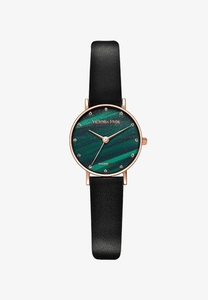 Rund ur med en grøn bølgemønstret urskive, rose gold detaljer og krystalmarkeringer. Har et sort tekstureret læderrem.