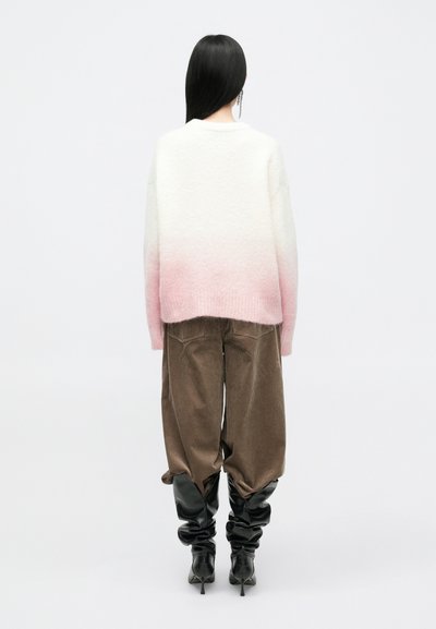 Sweater i hvid til lyserød gradient strik, oversized pasform. Sammen med brune fløjl bukser og sorte slouchy knæ-høje støvler.