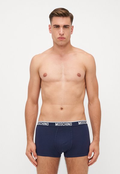Temno modri bombažni bokserji z belo elastiko, na kateri je v debelem tisku napisano "MOSCHINO". Mehka tekstura in oprijet oblikovanje.