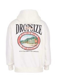 Weißer Hoodie mit Kapuze, verziert mit dem Text "DROPSIZE Clothing", einem Grafikmotiv von einem Strandhotel und dem Slogan "Worldwide Luxury Streetwear" sowie einem motivierenden Spruch.