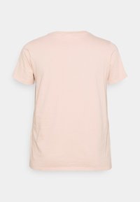 T-shirt a maniche corte in morbido cotone rosa chiaro; presenta un collo rotondo e una vestibilità comoda; texture liscia con un design semplice.