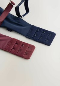 Twee bandsecties in donker marineblauw en bordeaux stof, met textured uiteinden en meerdere haak-en-lus sluitingen voor een verstelbare pasvorm.