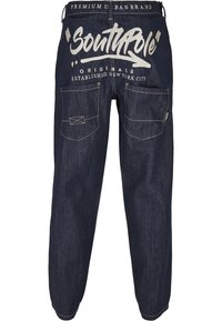 Pantalon en denim bleu foncé avec logo "SouthPole" imprimé à l'arrière. Coupe ample avec multiples poches et accents de coutures dorées.