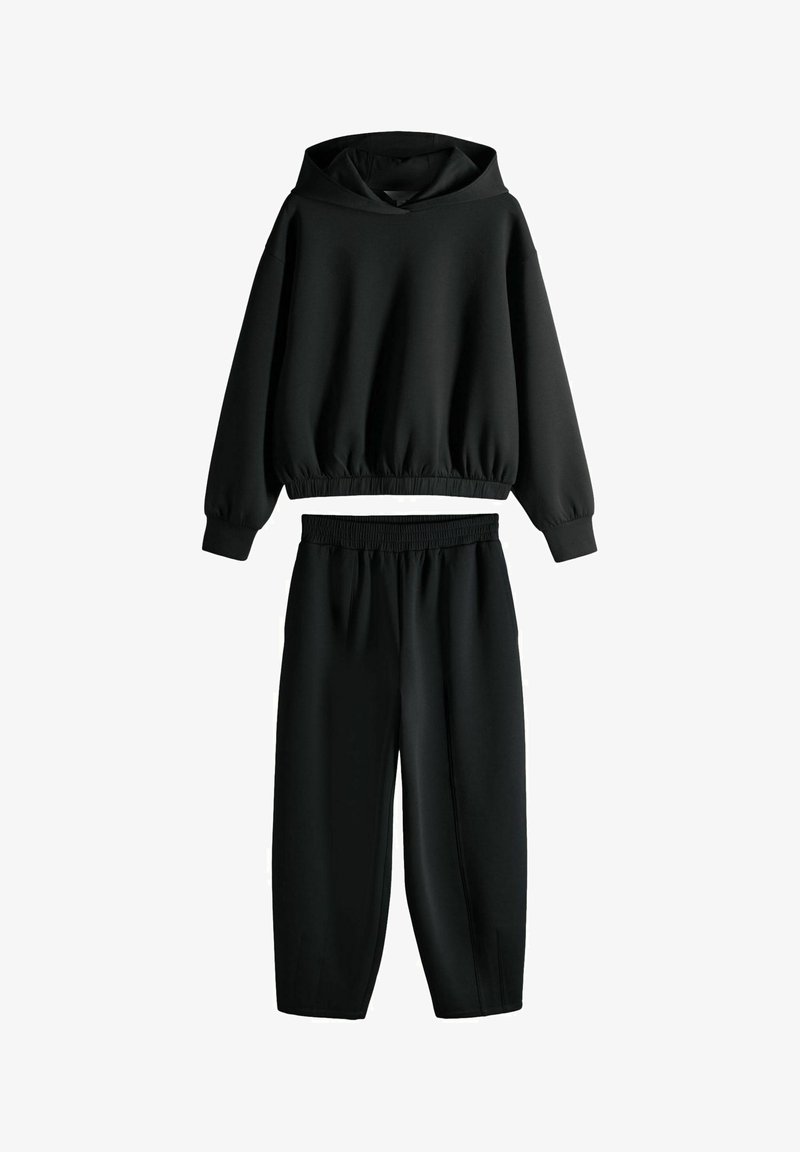 Zwart tweedelig set met een cropped sweatshirt met capuchon en elastische tailleband, en hoge taille elastische broek, beide gemaakt van zachte, rekbare stof.