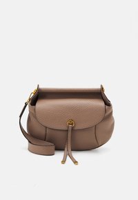 Torebka crossbody z fakturowanej skóry w kolorze taupe, z klapą, detalem w złotym odcieniu w kształcie pierścienia oraz regulowanym paskiem na białym tle.