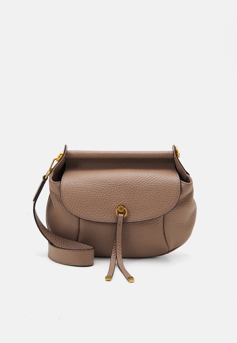 Torebka crossbody z fakturowanej skóry w kolorze taupe, z klapą, detalem w złotym odcieniu w kształcie pierścienia oraz regulowanym paskiem na białym tle.