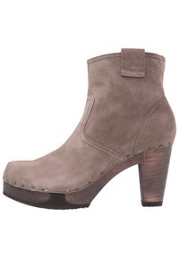 Suede ankle boot in taupe with a rounded toe, chunky heel, and decorative metal rivets along the base. Features a pull tab at the back.