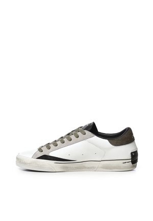 Sneaker bianca bassa con lacci grigi, dettagli neri e grigi, e suola in gomma leggermente consumata vista di profilo.