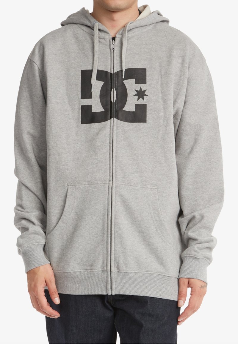 Hoodie zippé gris en fleece doux, avec un grand logo noir sur le devant, une capuche avec cordon de serrage et des poches avant.