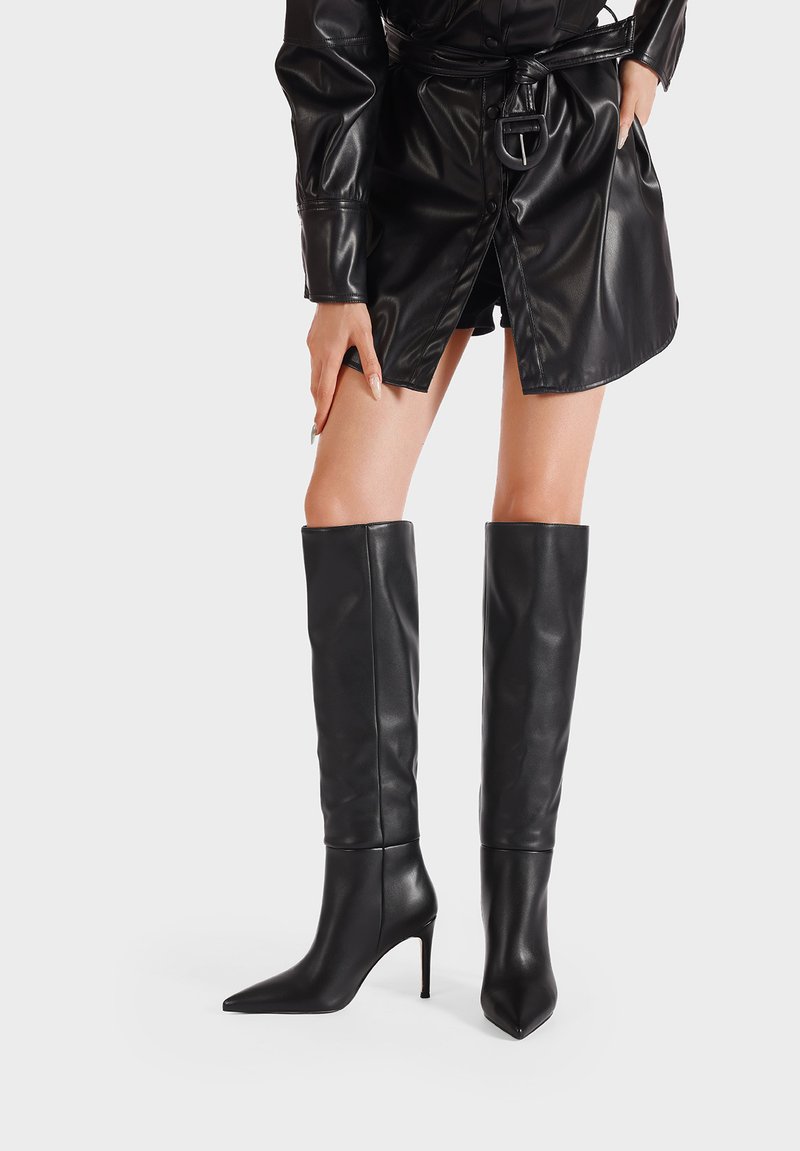 Stivali neri al ginocchio realizzati in pelle liscia, con punta affilata e tacco a spillo, dal profilo aderente.