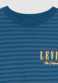 T-shirt azul com riscas, apresentando um decote redondo, textura suave e um colorido logótipo "Levi's" no lado esquerdo do peito.