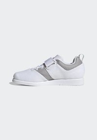 Zapatilla deportiva blanca con tela de malla y acentos grises, que cuenta con una correa frontal, puntera redondeada y una suela texturizada para mayor agarre.