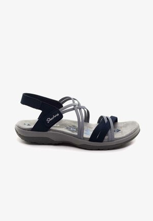 Sport sandal featuring a dark blue and gray design, elastic straps, cushioned gray sole, and textured footbed with geometric patterns.