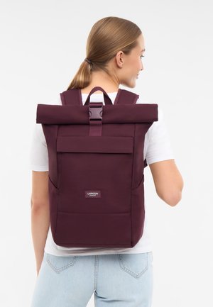 Zaino a roll-top in tessuto bordeaux profondo con spallacci regolabili, tasca frontale e tasche laterali in rete. Presenta un logo del marchio alla base.