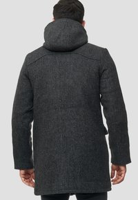 Dunkelgrauer Wollmantel mit Kapuze, mit strukturiertem Gewebe, geradem Schnitt und Gesäßtaschen. Schlichtes Design mit minimalen Hardware-Akzenten.