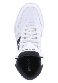 Hvide sportsko med sorte detaljer, der har en glat læderoverdel, rund tå, flade snørebånd og en polstret krave. "adidas" logoet er synligt.