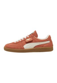 Sneaker in suede arancione con accenti bianchi, suola in gomma e lacci piatti. Presenta un'etichetta con logo sul lato e un design a profilo basso e slanciato.