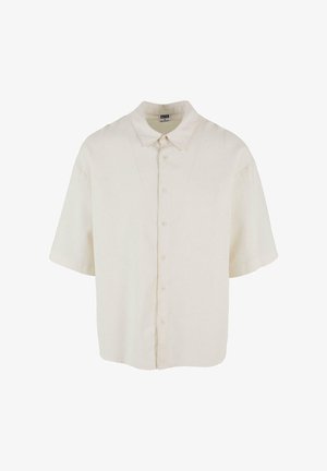 Chemise à manches courtes en tissu couleur crème, avec une coupe décontractée, une fermeture par boutons et un col classique.